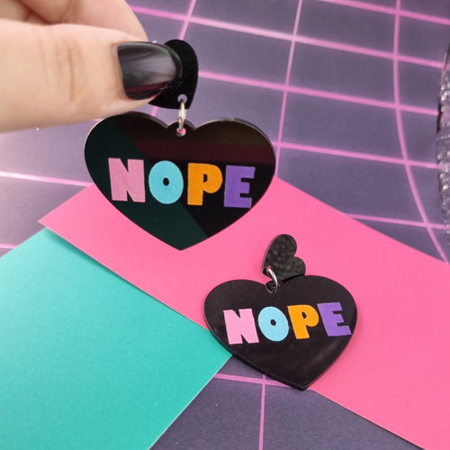 Black heart drop earrings with pastel multicolour NOPE lettering, view 2