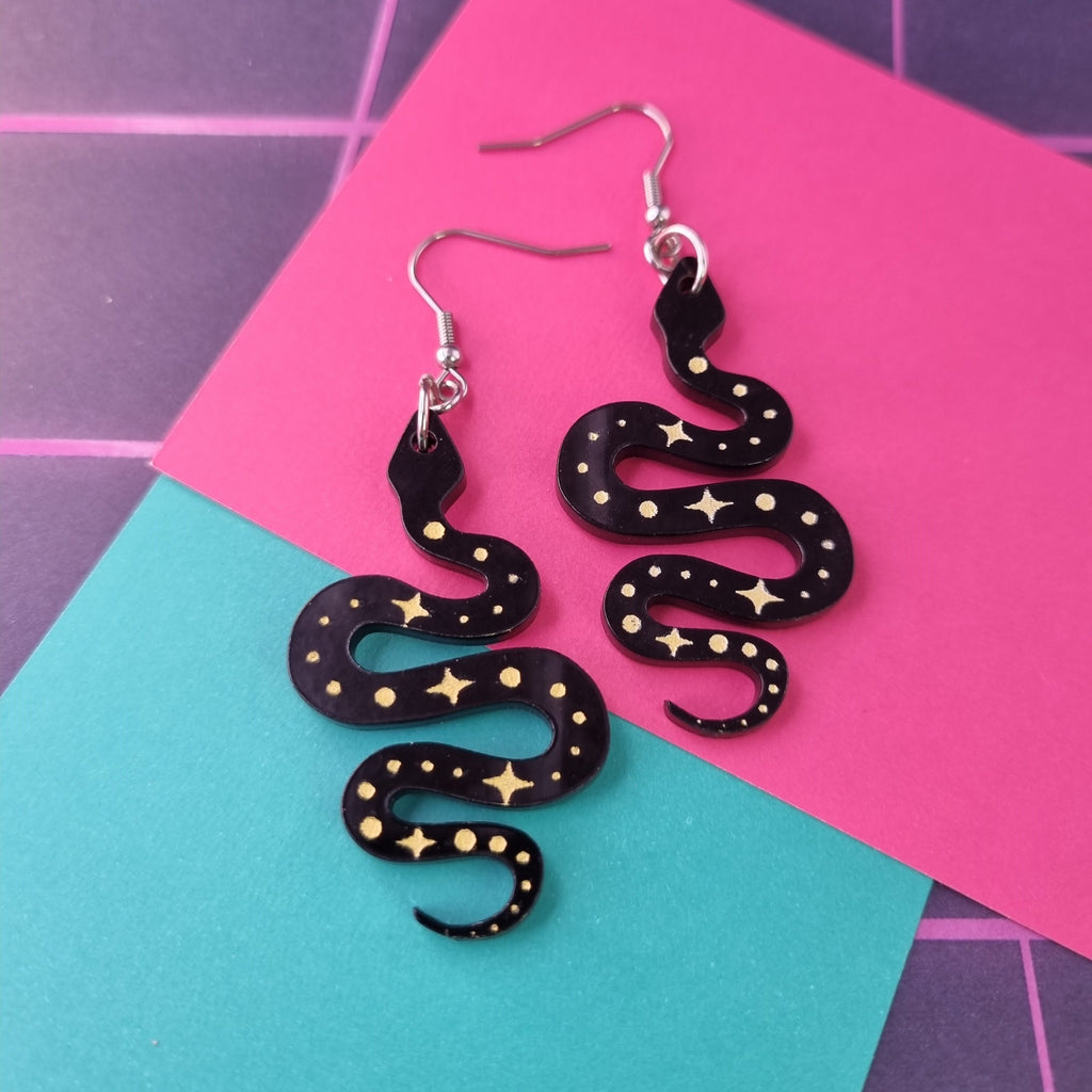 Black acrylic snake earrings with gold stars and dots