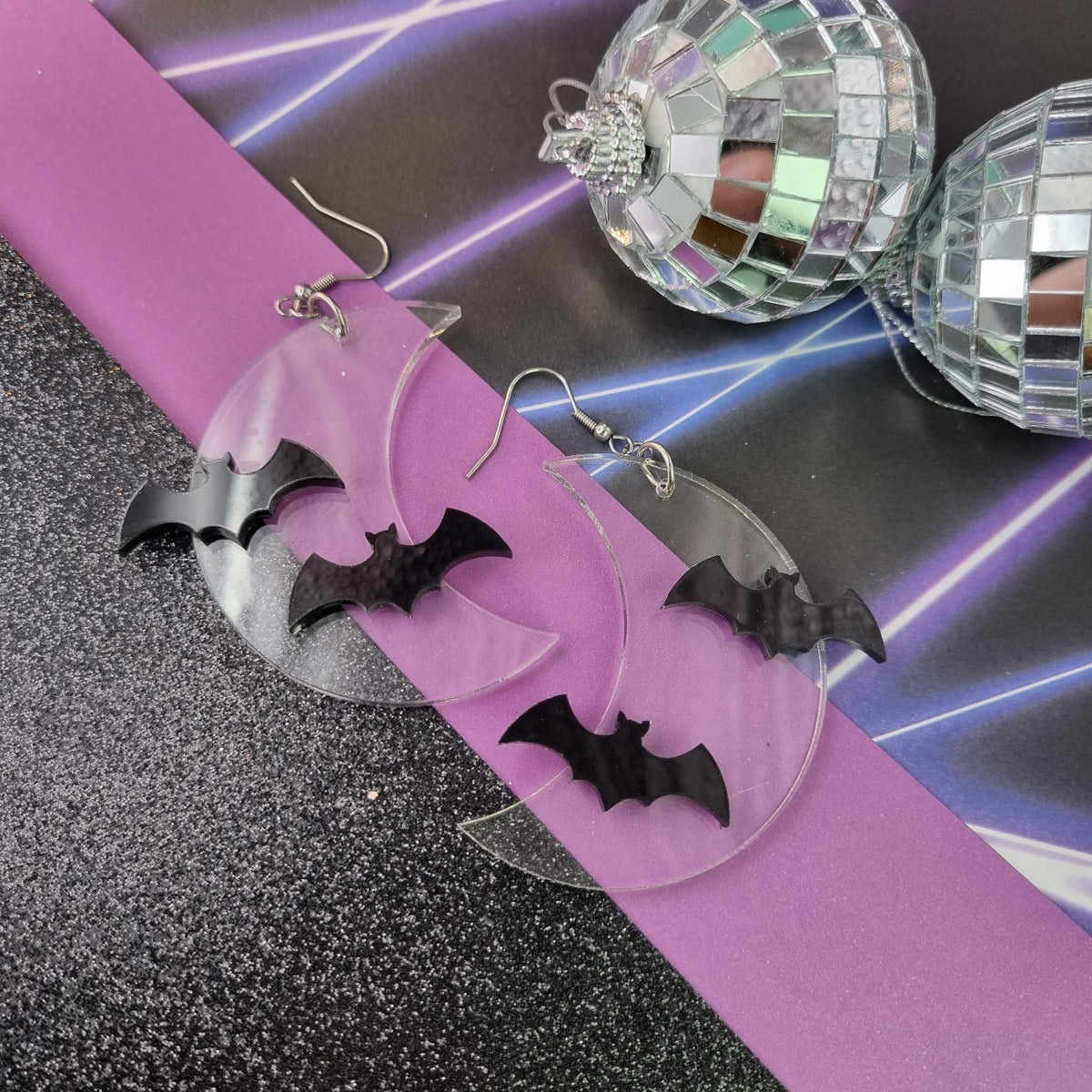Clear acrylic crescent moon earrings with two black bats, view 2