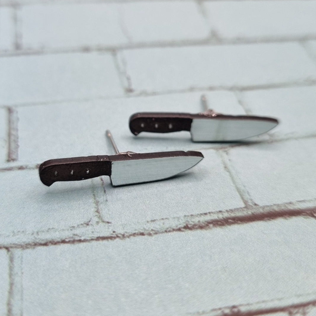Small chef knife stud earrings with dark handles and silver blades