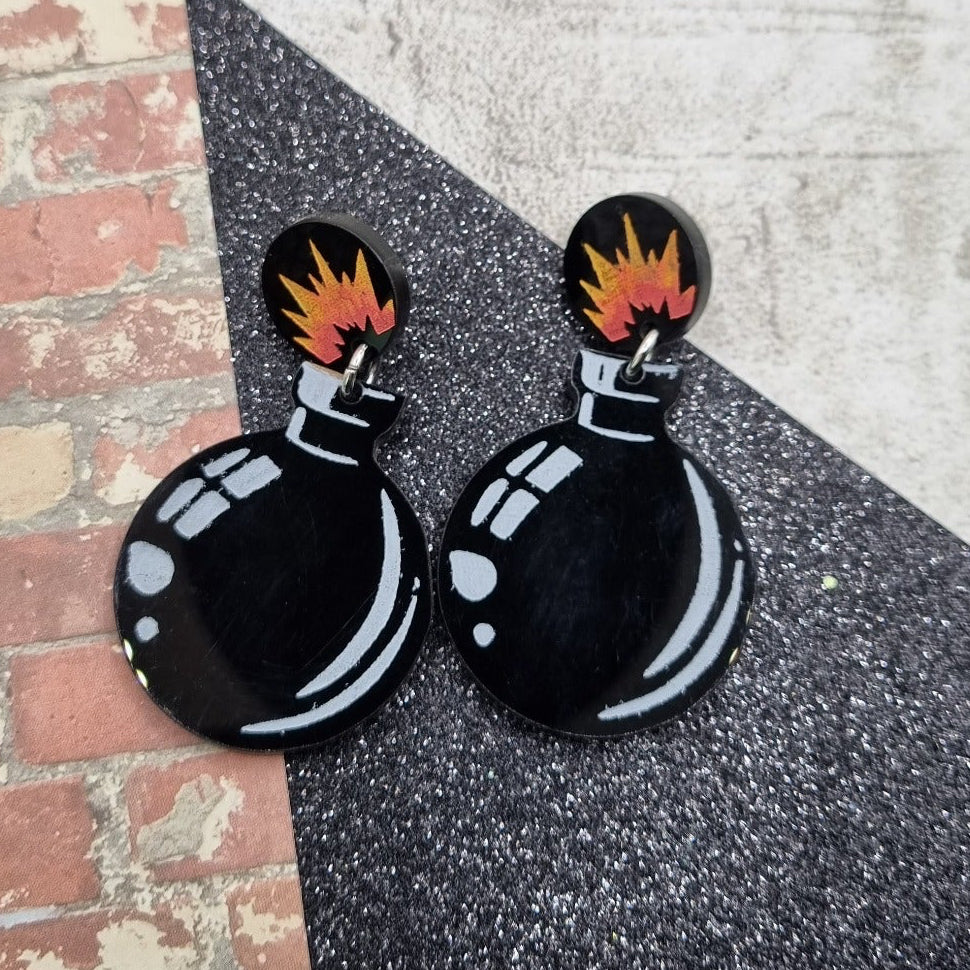 Black cartoon bomb drop earrings with flame burst stud tops