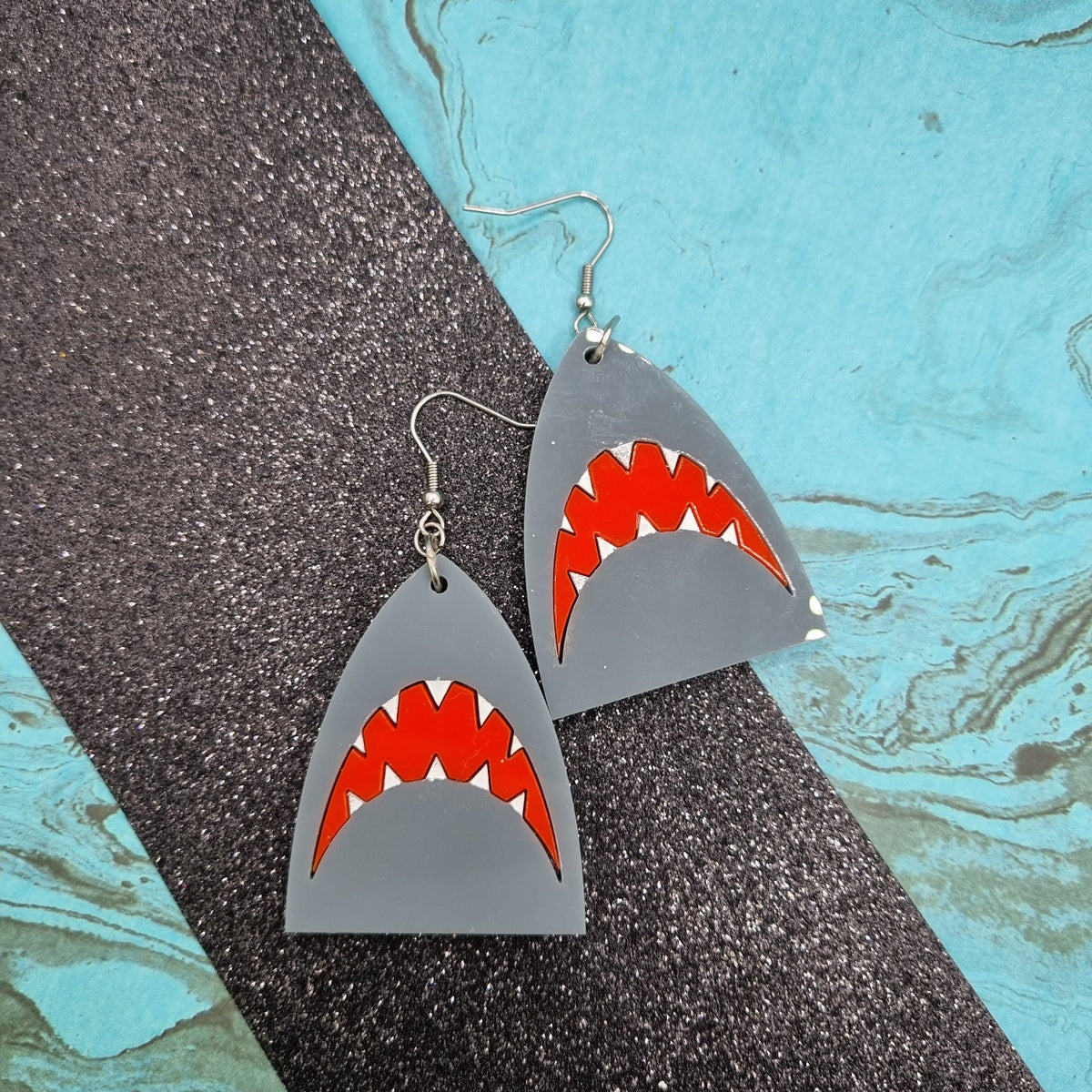 Grey acrylic shark fin earrings with open red mouth and white teeth