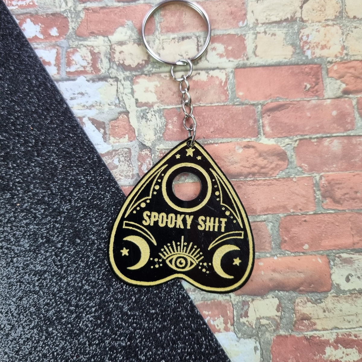 Black acrylic planchette keyring with gold Spooky Shit lettering
