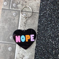 Black heart keyring with pastel multicolour NOPE lettering