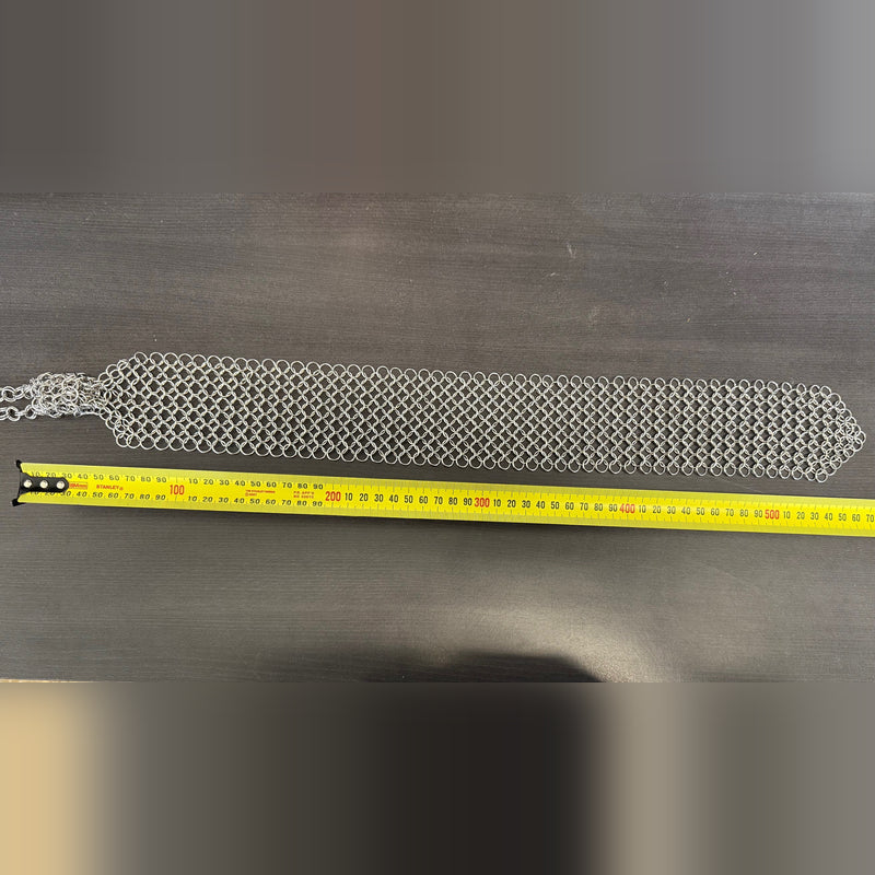 Chain maille tie measured against a tape measure